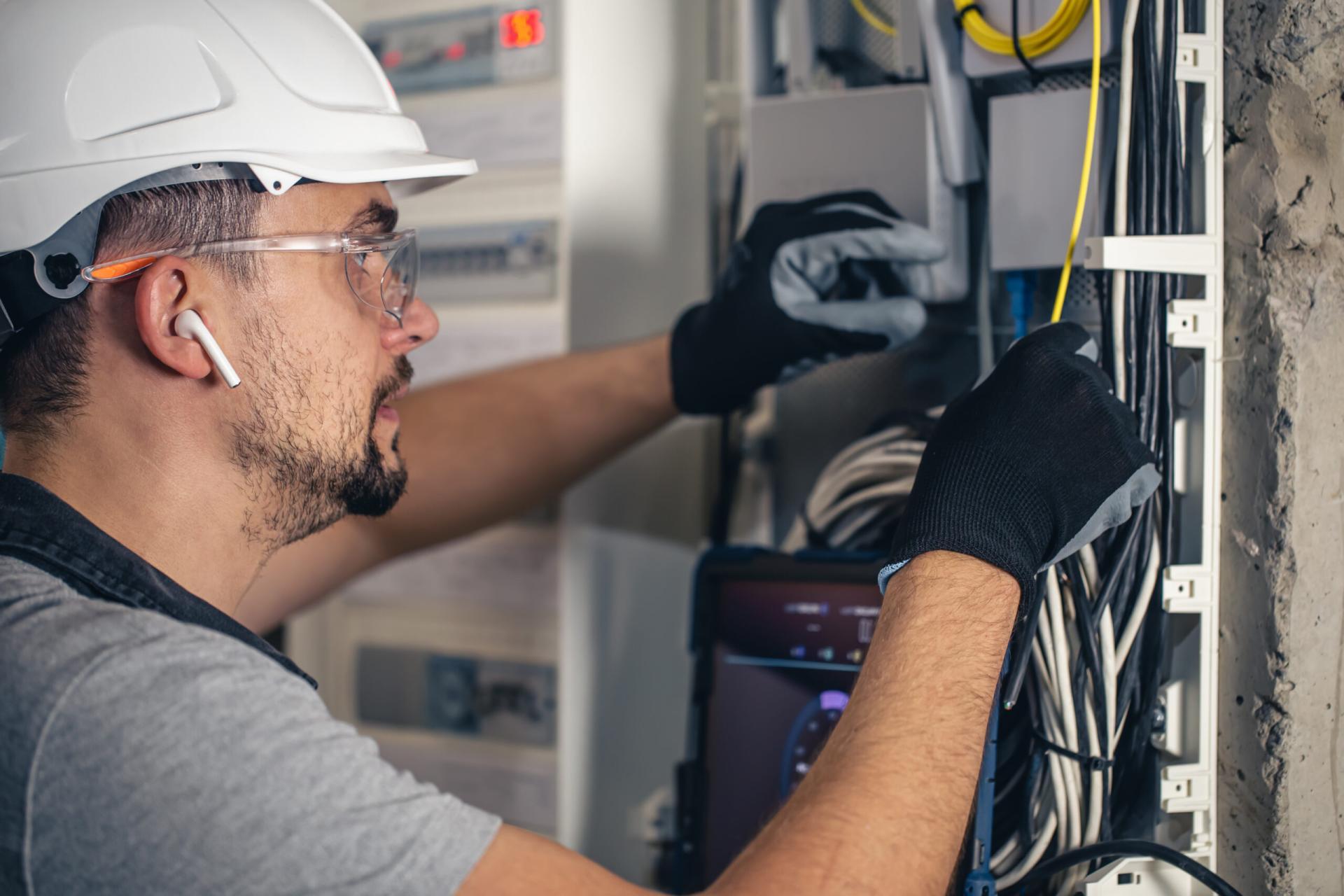 uomo un tecnico elettrico che lavora in un quadro elettrico con fusibili 1 scaled